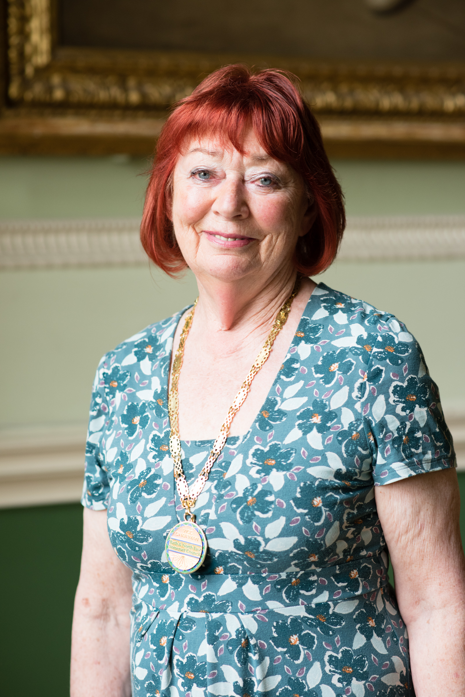 A portrait image of Councillor Liz Hardman, Vice Chair of the council. A red-haired lady in a blue, floral dress