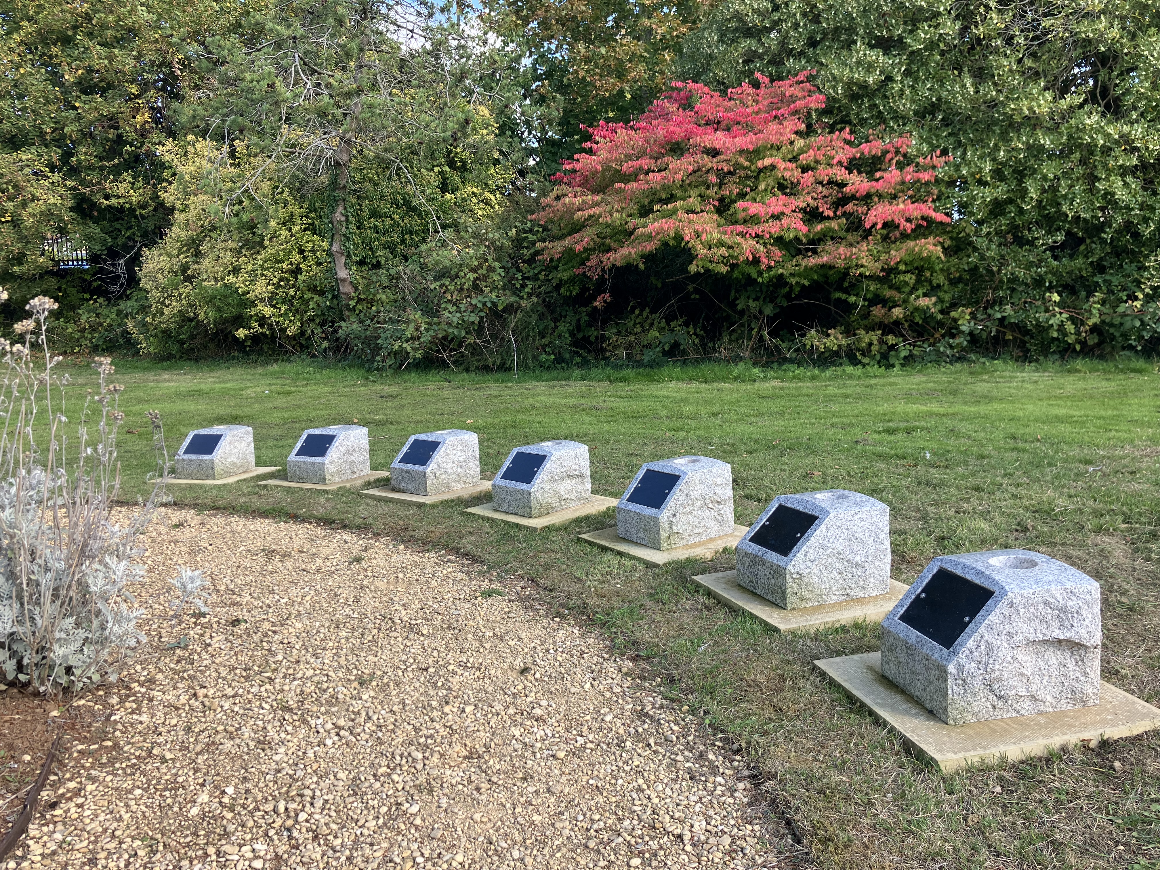 Open a large version of this image A semi circle of memorial boulders arranged around a gravel path