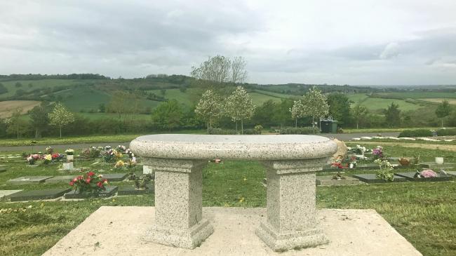 curved bench viewed from behind, with Haycombe views