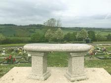 curved bench viewed from behind, with Haycombe views